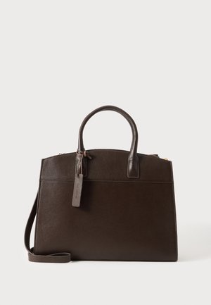 Dunkelbraune Lederhandtasche mit zwei Henkeln, einem abnehmbaren Schultergurt und einem hängenden Lederanhänger vor einfarbigem Hintergrund.