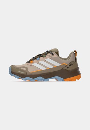Beige, brune og orange Adidas Terrex vandresko med hvide striber, blå og orange sål, sorte snørebånd og Gore-Tex label på siden.