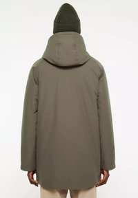 Olijfgroene gewatteerde jas met een capuchon, met een gladde, matte textuur en een rechte snit. G gedragen met een bijpassende gebreide beanie.