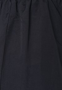 Dark blue fabric with a smooth texture, featuring pleats at the waistband. The design is simple and classic, suitable for various occasions.