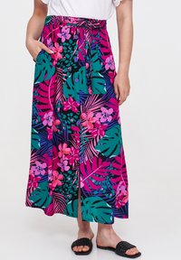 Maxi spódnica z żywym wzorem kwiatów i liści w odcieniach różu, zieleni i czerni. Wykonana z lekkiego materiału, z wiązaniem w talii i kieszeniami.