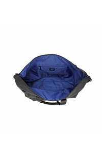 Melnas auduma soma ar plašu zilu iekšpusi, aprīkota ar rāvējslēdzēja kabatu un divām rokturiem nēsāšanai.