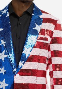 Paillettenblazer met een halvemaan patroon in rood en witte strepen aan de ene kant en blauw met witte sterren aan de andere kant. Sluitingen bestaan uit één knop en revers.