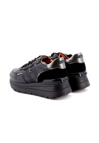 Sneakers neri con una tomaia in pelle liscia e dettagli in suede, suola spessa e particolari metallici sul tallone. I lacci sono di colore dorato.