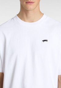 Hvid bomulds T-shirt med en lille sort skateboard broderi på brystet, rund halsudskæring og korte ærmer med en glat tekstur.