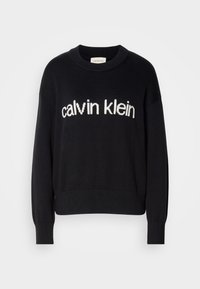 Pull en maille noir à manches longues avec poignets et ourlet côtelés, avec le texte blanc "calvin klein" sur la poitrine.