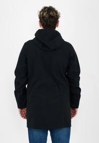 Veste noire à capuche avec des manches longues, fabriquée à partir d'un matériau lisse. Présente une coupe droite et des détails de couture visibles dans le dos.