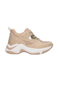 Zapatilla deportiva beige con una parte superior texturizada, adornada con strass, mediasuela blanca y suela exterior ligeramente curvada para mayor soporte.