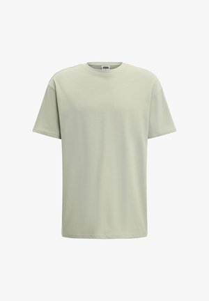 Svijetlozelena majica s kratkim rukavima i okruglim izrezom, izrađena od mekog pamuka. Glatka tekstura, opušteni kroj, minimalistički dizajn, bez uzoraka ili detalja.