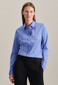 Blauwe langekleurige blouse met knopen, met een fitted ontwerp en een subtiel streepjespatroon. Heeft een kraag en geborduurde accenten aan de zoom.
