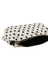 Pochette à pois blancs et noirs avec une fermeture éclair dorée et des accents noirs, présentant un design épuré et une texture en tissu.