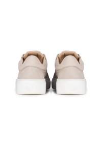 Sneaker beige con una parte superiore leggera e testurizzata e una suola in gomma bianca a contrasto. La parte posteriore presenta un design liscio senza branding visibile.