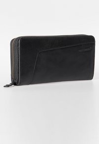 Portafoglio in pelle nera con texture morbida, chiusura a zip e design elegante con un sottile accento curvo su un lato.