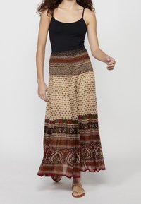 Maxi skirt with elastic waistband, featuring a multicolored patterned design of floral and geometric motifs on a light background.
