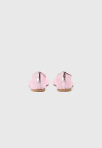 Sapatos de pele rosa com um detalhe em prata metálica na parte de trás. Sola plana, design de bico redondo, textura suave e detalhes de costura mínimos.