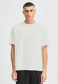 Crew neck, short-sleeved, off-white t-shirt made of soft fabric, featuring a relaxed fit and minimalistic design.