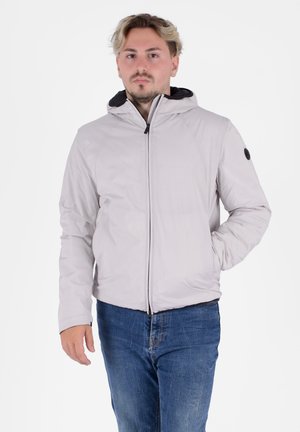 Giacca a zip grigio chiaro con cappuccio, tasche laterali e dettagli neri; presenta una texture liscia e un design aderente.