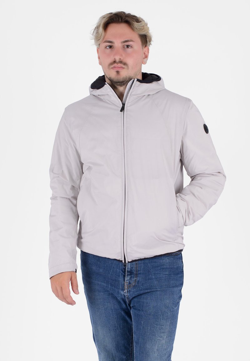 Giacca a zip grigio chiaro con cappuccio, tasche laterali e dettagli neri; presenta una texture liscia e un design aderente.