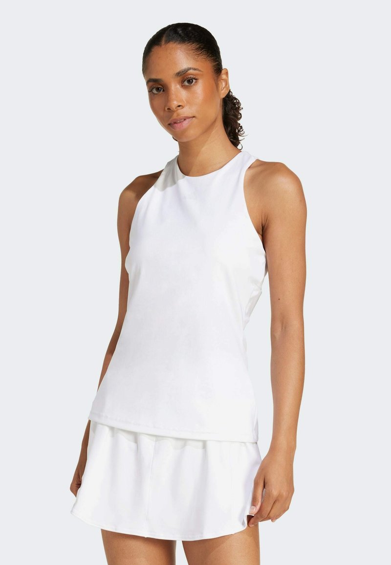 White athletic tank top with a high neckline and sleeveless design. Smooth, lightweight fabric with a relaxed fit and layered hem.