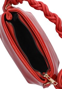 Rode leren handtas met een gevlochten schouderband, een ritssluiting en een zachte zwarte voering. Gladde textuur met een glanzende afwerking.
