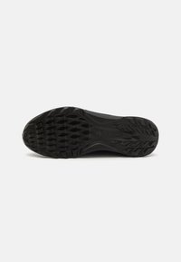 Black rubber shoe sole featuring an textured pattern with hexagonal grips and curved edges, designed for traction and flexibility.