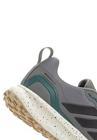 Zapatillas gris repelentes al agua con parte superior de malla texturizada, detalles en verde y una suela moteada blanca y beige. Cuentan con un tirador en el talón.