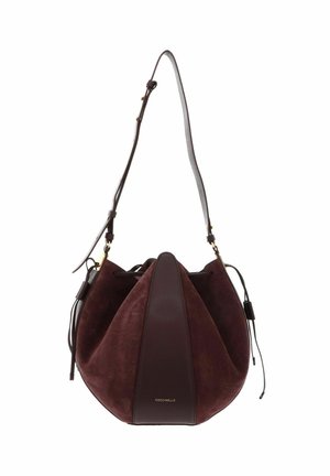 Sac seau en daim et cuir marron avec une sangle réglable et une fermeture à cordon, avec un petit lettrage doré.