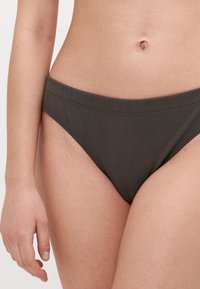 Ciemnozielone bawełniane figi bikini z miękką, elastyczną talią i gładką teksturą, o klasycznym kroju i minimalnych detalach.