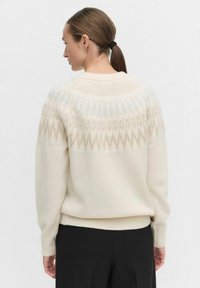 Romantische sweater met een geometrisch patroon in zachte blauw- en beigetinten, met ribbels aan de mouwen en onderkant. Soepele textuur en een relaxte pasvorm.