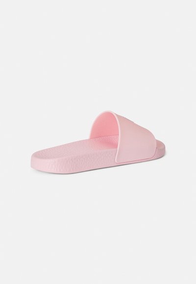 Rosa gummi-sandal med en buet øvre stropp og teksturert fotseng. Har en flat såle og minimalistisk design uten pynt.