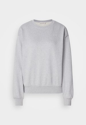 Grå bomullssweatshirt med lange ermer, rund halslinning, ribbede mansjetter og nederkant, med en subtil brodert logo på brystet.