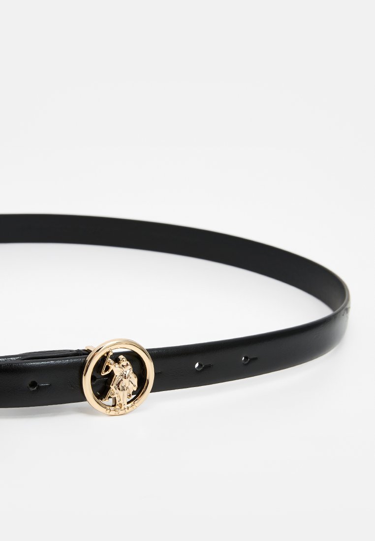 Ceinture en cuir noir avec une boucle circulaire en or ornée d'un design en relief. La ceinture possède plusieurs trous pour un ajustement de taille.
