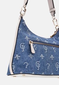 Niebieska torba z denimu z białym motywem fleur-de-lis i monogramem, przednia kieszeń na zamek, białe ozdobne wykończenie i złote zapięcia na regulowanym pasku.