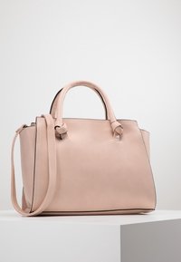 Borsa a mano in pelle rosa strutturata con manici superiori doppi e tracolla removibile. Caratterizzata da una superficie liscia e un design minimalista.