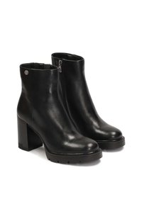 Botines de cuero negro hasta el tobillo con tacón cuadrado, punta redondeada, cremallera lateral y suela texturizada. Incluye un pequeño logo en la parte trasera.