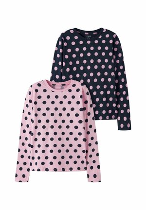 Deux chemises à manches longues avec col rond, une rose avec de gros pois noirs, l'autre noire avec de gros pois roses.
