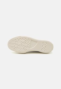 Sneaker sole in off-white rubber featuring a geometric tread pattern, round toe, and branding text. Smooth texture with slight flex.