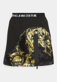 Svart kjol med gyllene barocktryck på satinsidan, elastisk midja med "Versace Jeans Couture"-logotyp, har sidodetalj med dragkedja.