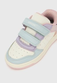 Gyerekcipő lágy pasztell színpalettával: halványkék, levendula és krémszín. Velcro pántokkal és lyukacsos mintázattal a lábujjnál.