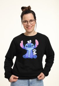 Černá mikina s barevn�ým grafickým obrázkem kreslené postavy s velkýma ušima a malými ptáčky na ní sedícími.