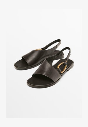 Zwarte leren sandalen met een open teen en achterkantriem, accentueerd met een gouden gespte. Gekleurde textuur met een platte zoolontwerp.