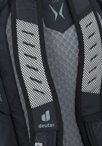 Primer plano del panel trasero de una mochila Deuter en negro y gris, con correas acolchadas de malla y tela de ventilación con patrón hexagonal.