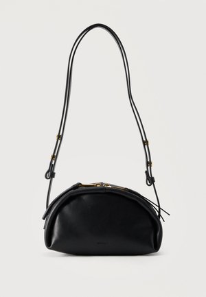 Sort læder håndtaske crescentformet med justerbar tynd dobbelt skulderrem og guldfarvede beslag på minimal hvid baggrund.