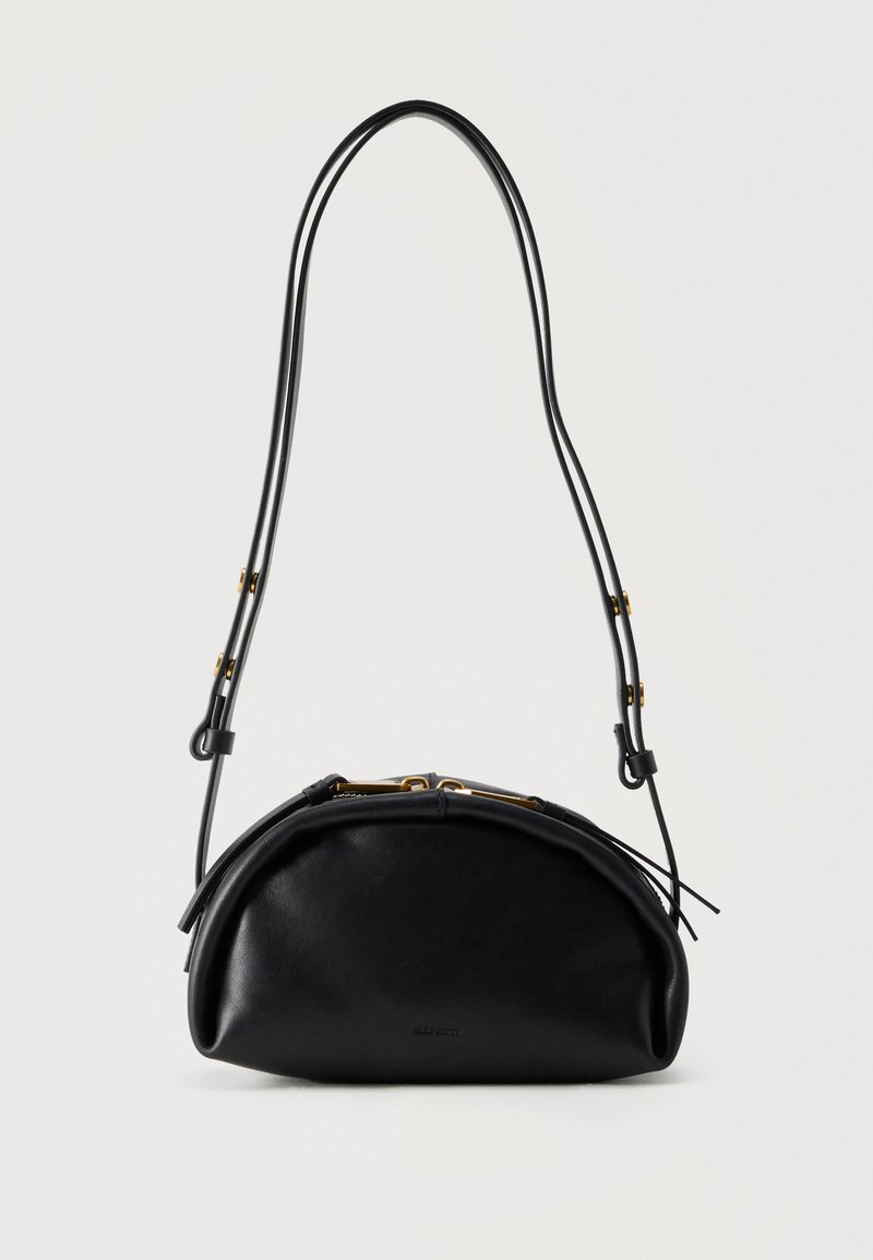 Μαύρη δερμάτινη τσάντα σε σχήμα ημισελήνου με ρυθμιζόμενο λεπτό διπλό λουρί ώμου και εξαρτήματα σε χρυσή απόχρωση σε μινιμαλιστικό λευκό φόντο.
