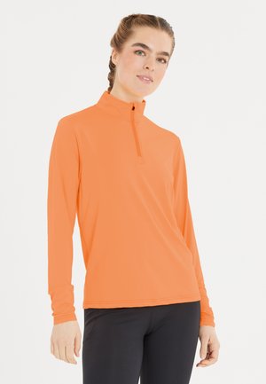Långärmad topp med kvartdragkedja i ett livfullt orange tyg. Slät textur med en figurbetonad design, accentuerad av en minimalistisk krage och sömmar.