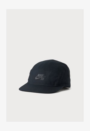 Casquette Nike SB noire à cinq panneaux avec une visière plate, arborant le logo Nike et le texte "SB" brodé à l'avant.