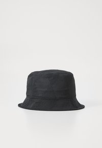 Zwarte bucket hat van textuurstof, met een subtiel geometrisch patroon en een brede, flexibele rand.