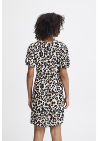 Leopardenmuster-Kleid mit kurzen, fließenden Ärmeln, einer taillierten Taille und einem weiten Rock in Schwarz-, Gold- und Cremetönen.