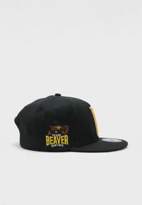 Musta snapback-lippis, jossa on tasainen lippa. Siinä on sarjakuvamainen majava-logo ja keltainen brodeeraus tekstillä "TEXAS BEAVER HUNTERS". Pehmeä kangas.