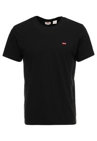 T-shirt noir à manches courtes et col rond avec une petite étiquette rouge Levi's sur la poitrine gauche.